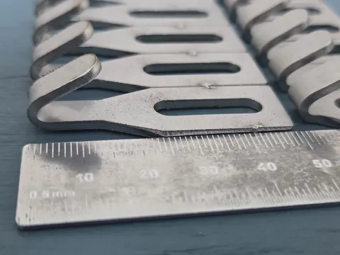 Close-up of a row of stainless centre hooks with a steel rule